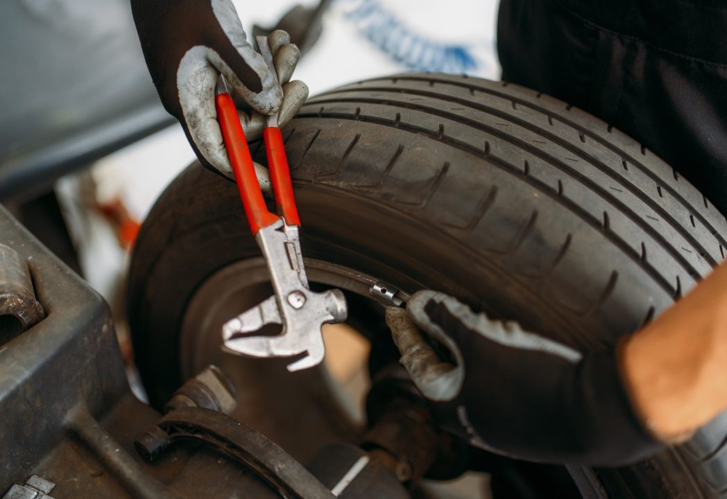 Auto mechanic balancing wheel, tire service